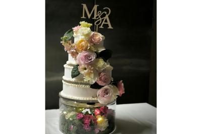 Salle de bain lumineuse avec vasque blanche, serviettes pliées et vue sur un jardin à travers une porte-fenêtre.