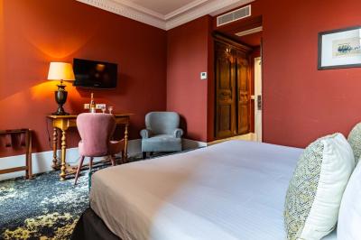 Salle de bain lumineuse avec vasque blanche, serviettes pliées et vue sur un jardin à travers une porte-fenêtre.