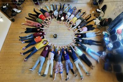 Un groupe de personnes souriantes rassemblées dans une ambiance conviviale lors d'un événement en intérieur.
