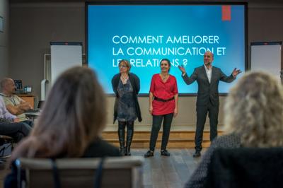 Un groupe de personnes souriantes rassemblées dans une ambiance conviviale lors d'un événement en intérieur.