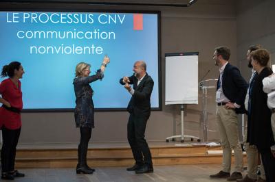 Un groupe de personnes souriantes rassemblées dans une ambiance conviviale lors d'un événement en intérieur.