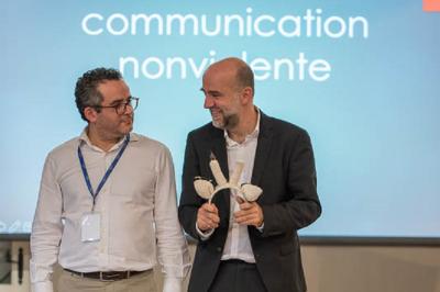 Un groupe de personnes souriantes rassemblées dans une ambiance conviviale lors d'un événement en intérieur.