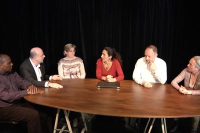 Un groupe de personnes souriantes rassemblées dans une ambiance conviviale lors d'un événement en intérieur.