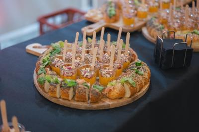 Miniature Cocktail Minutes Papillons Personne disposant des verrines individuelles garnies de crumble sur un plateau dans une cuisine professionnelle.