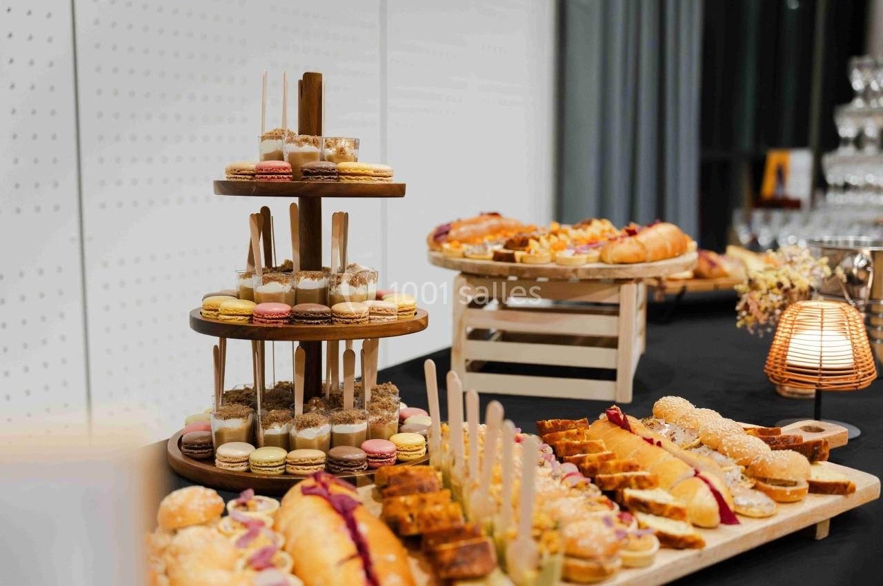 Plateau de pâtisseries variées avec macarons, gâteaux et viennoiseries disposés sur une table de réception.