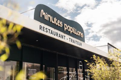 Miniature Façade extérieure Minutes Papillons Personne disposant des verrines individuelles garnies de crumble sur un plateau dans une cuisine professionnelle.