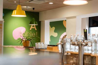 Miniature Salle de restaurant Minutes Papillons Personne disposant des verrines individuelles garnies de crumble sur un plateau dans une cuisine professionnelle.