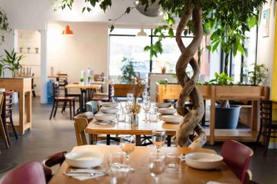 Miniature Salle de restaurant Minutes Papillons Personne disposant des verrines individuelles garnies de crumble sur un plateau dans une cuisine professionnelle.