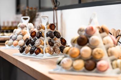 Présentoirs en forme de pyramide garnis de macarons et de petits choux, disposés sur un comptoir en bois.