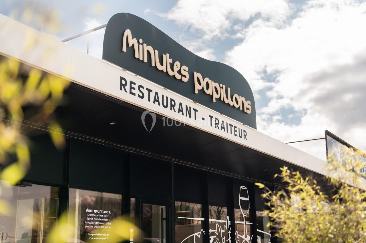 Façade d'un restaurant-traiteur nommé ’Minutes Papillons’, avec un ciel partiellement nuageux en arrière-plan.
