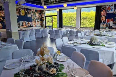 Miniature Location salle Cluses (Haute-Savoie) - Salle du Mont Blanc #2 Comptoir de bar décoré de guirlandes lumineuses, fleurs jaunes et blanches, avec un éclairage bleu en arrière-plan.