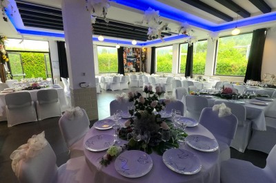 Miniature Location salle Cluses (Haute-Savoie) - Salle du Mont Blanc #8 Comptoir de bar décoré de guirlandes lumineuses, fleurs jaunes et blanches, avec un éclairage bleu en arrière-plan.