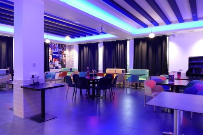 Miniature Location salle Cluses (Haute-Savoie) - Salle du Mont Blanc #18 Comptoir de bar décoré de guirlandes lumineuses, fleurs jaunes et blanches, avec un éclairage bleu en arrière-plan.