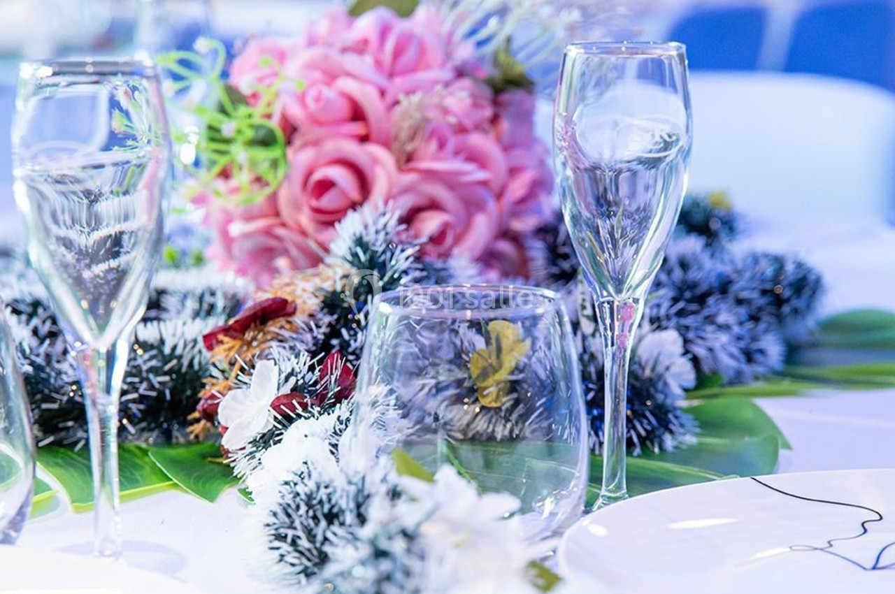 Table décorée avec des verres à pied, bouquet de roses roses et ornements végétaux givrés.