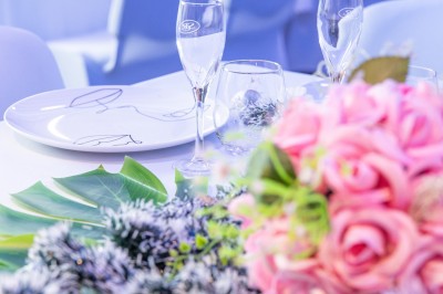 Miniature Location salle Cluses (Haute-Savoie) - Salle du Mont Blanc #11 Comptoir de bar décoré de guirlandes lumineuses, fleurs jaunes et blanches, avec un éclairage bleu en arrière-plan.