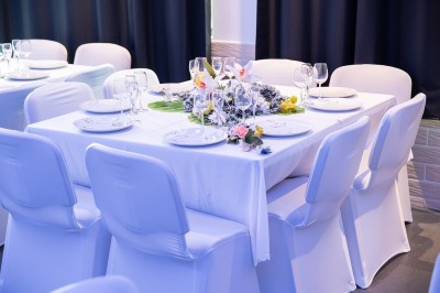 Miniature Location salle Cluses (Haute-Savoie) - Salle du Mont Blanc #7 Comptoir de bar décoré de guirlandes lumineuses, fleurs jaunes et blanches, avec un éclairage bleu en arrière-plan.