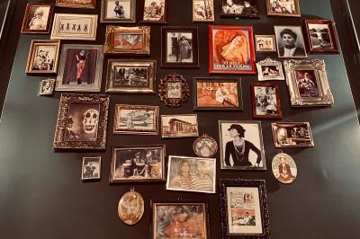 Salle de restaurant cosy avec fauteuils imprimés, éclairage tamisé et plafond décoré de motifs floraux.