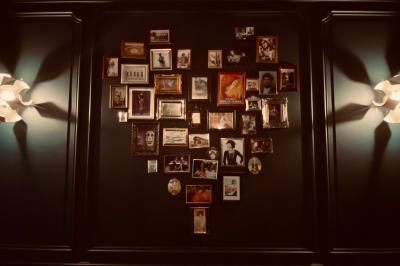 Salle de restaurant cosy avec fauteuils imprimés, éclairage tamisé et plafond décoré de motifs floraux.