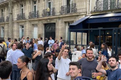 Salle de restaurant cosy avec fauteuils imprimés, éclairage tamisé et plafond décoré de motifs floraux.