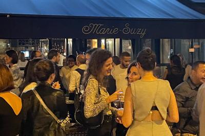 Salle de restaurant cosy avec fauteuils imprimés, éclairage tamisé et plafond décoré de motifs floraux.