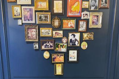 Salle de restaurant cosy avec fauteuils imprimés, éclairage tamisé et plafond décoré de motifs floraux.