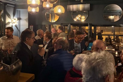 Salle de restaurant cosy avec fauteuils imprimés, éclairage tamisé et plafond décoré de motifs floraux.