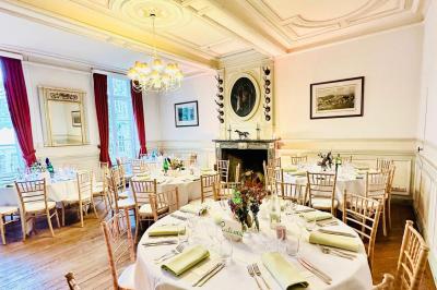 Dîner en plein air sous des guirlandes lumineuses, avec des invités assis autour de tables éclairées au crépuscule.