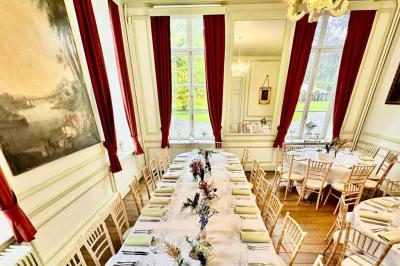 Dîner en plein air sous des guirlandes lumineuses, avec des invités assis autour de tables éclairées au crépuscule.