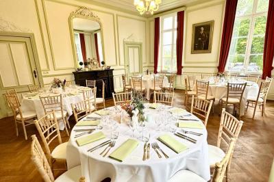 Dîner en plein air sous des guirlandes lumineuses, avec des invités assis autour de tables éclairées au crépuscule.