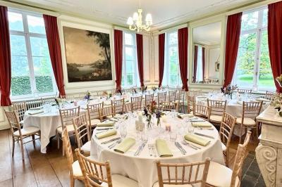 Dîner en plein air sous des guirlandes lumineuses, avec des invités assis autour de tables éclairées au crépuscule.