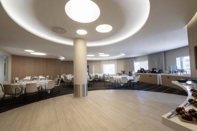 Trois distributeurs de savon fixés sur un mur de douche sombre, avec un éclairage jaune en reflet.