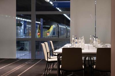 Trois distributeurs de savon fixés sur un mur de douche sombre, avec un éclairage jaune en reflet.