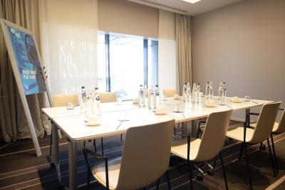 Trois distributeurs de savon fixés sur un mur de douche sombre, avec un éclairage jaune en reflet.