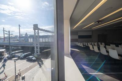 Trois distributeurs de savon fixés sur un mur de douche sombre, avec un éclairage jaune en reflet.