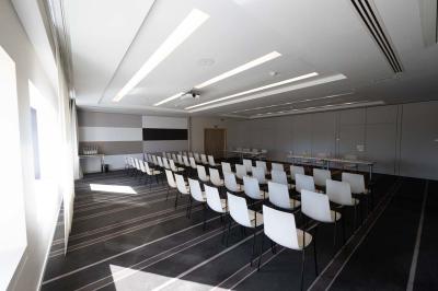 Trois distributeurs de savon fixés sur un mur de douche sombre, avec un éclairage jaune en reflet.