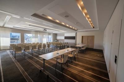 Trois distributeurs de savon fixés sur un mur de douche sombre, avec un éclairage jaune en reflet.