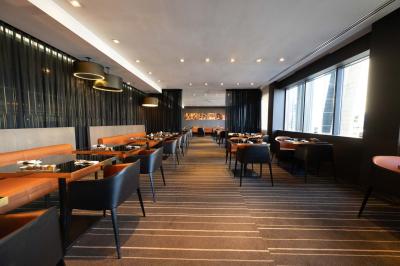 Trois distributeurs de savon fixés sur un mur de douche sombre, avec un éclairage jaune en reflet.