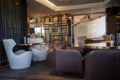 Trois distributeurs de savon fixés sur un mur de douche sombre, avec un éclairage jaune en reflet.