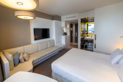 Trois distributeurs de savon fixés sur un mur de douche sombre, avec un éclairage jaune en reflet.