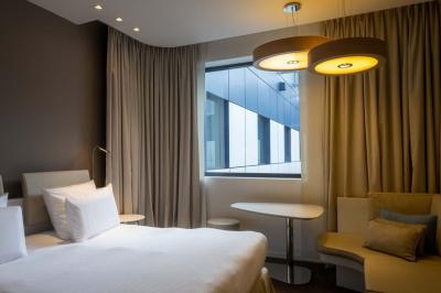 Trois distributeurs de savon fixés sur un mur de douche sombre, avec un éclairage jaune en reflet.