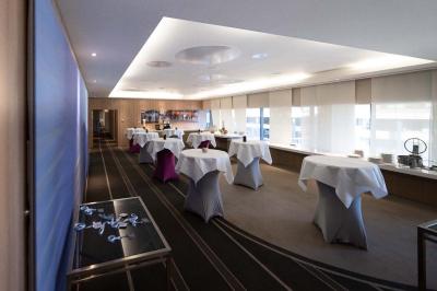 Trois distributeurs de savon fixés sur un mur de douche sombre, avec un éclairage jaune en reflet.