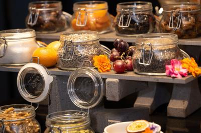 Trois distributeurs de savon fixés sur un mur de douche sombre, avec un éclairage jaune en reflet.