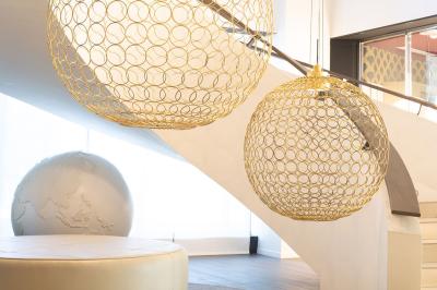 Trois distributeurs de savon fixés sur un mur de douche sombre, avec un éclairage jaune en reflet.