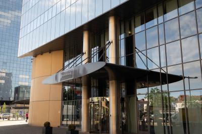 Trois distributeurs de savon fixés sur un mur de douche sombre, avec un éclairage jaune en reflet.
