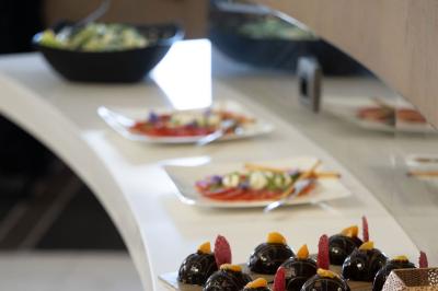 Trois distributeurs de savon fixés sur un mur de douche sombre, avec un éclairage jaune en reflet.