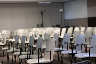 Trois distributeurs de savon fixés sur un mur de douche sombre, avec un éclairage jaune en reflet.