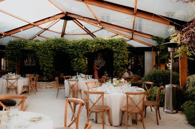 Un couple souriant marche main dans la main au milieu d'invités applaudissant lors d'une cérémonie en plein air.