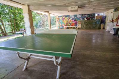 Deux lits simples avec couvre-lits bleus, une lampe de chevet, un bureau et un lavabo dans une chambre lumineuse.