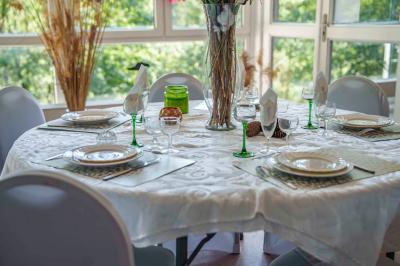 Deux lits simples avec couvre-lits bleus, une lampe de chevet, un bureau et un lavabo dans une chambre lumineuse.