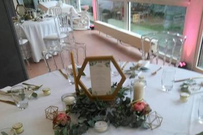 Deux lits simples avec couvre-lits bleus, une lampe de chevet, un bureau et un lavabo dans une chambre lumineuse.